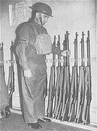 An Image Showing A Home Guard Member Checking his Unit's Rifles